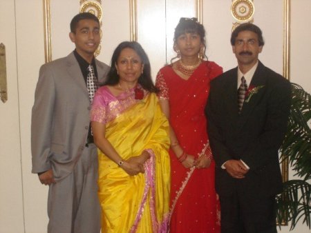 Jeffin Mathew and his family at a celebration. The women of the family are in traditional Indian dress, and the men are wearing contemporary American suits, symbolic of the mixture of cultures.